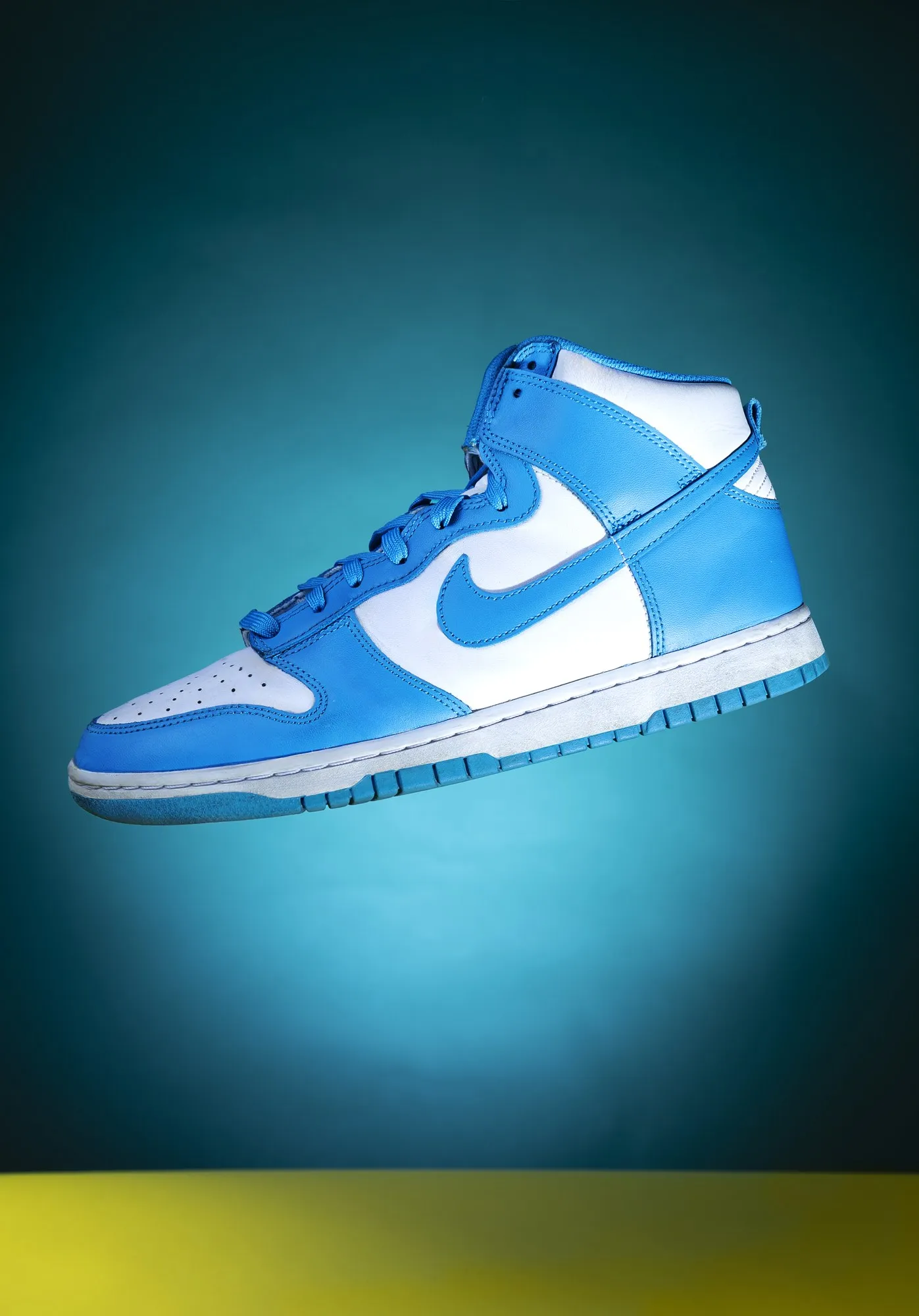 A blue-and-white sneaker is isolated against a deep teal background.