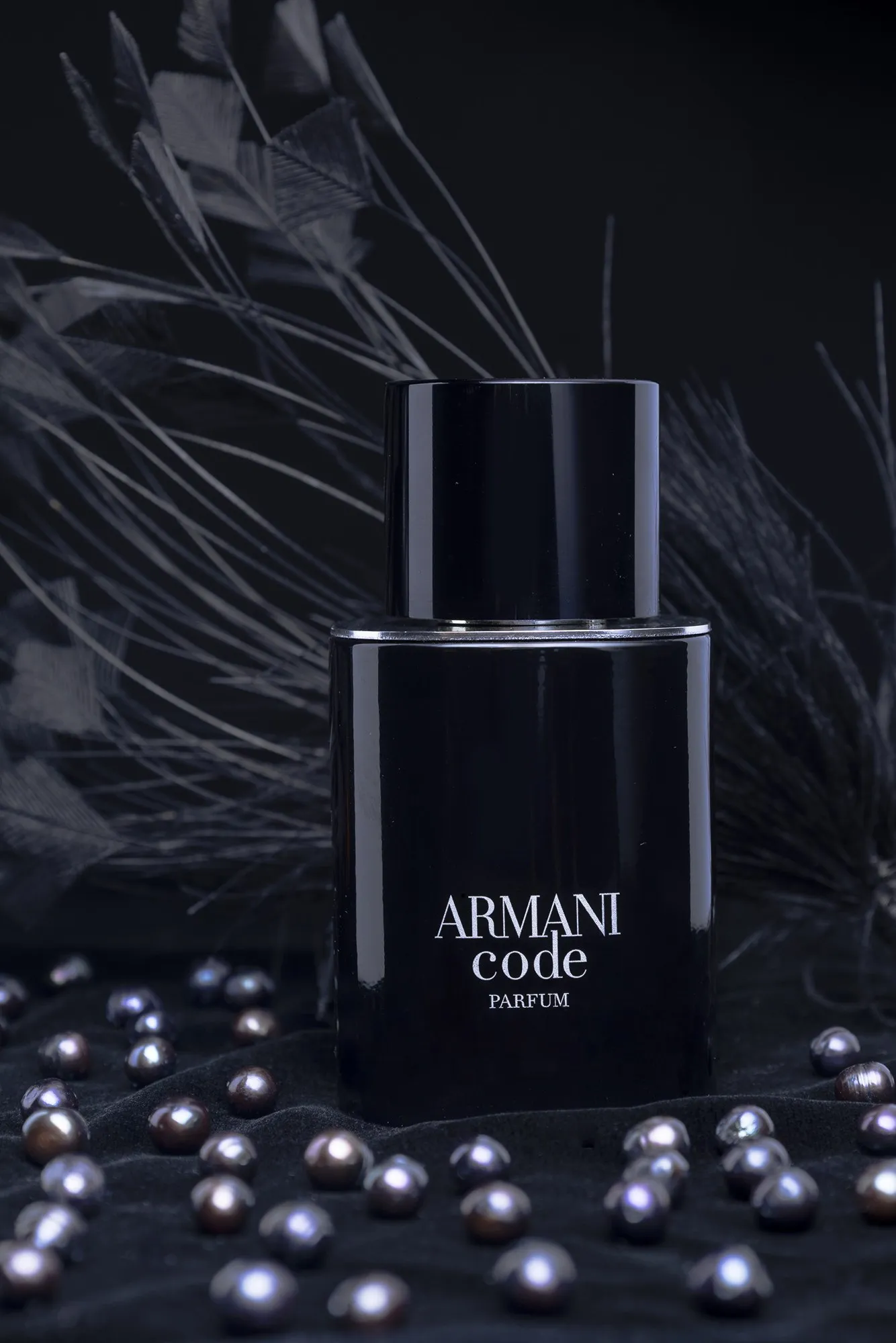 An Armani perfume bottle against textured black fabric