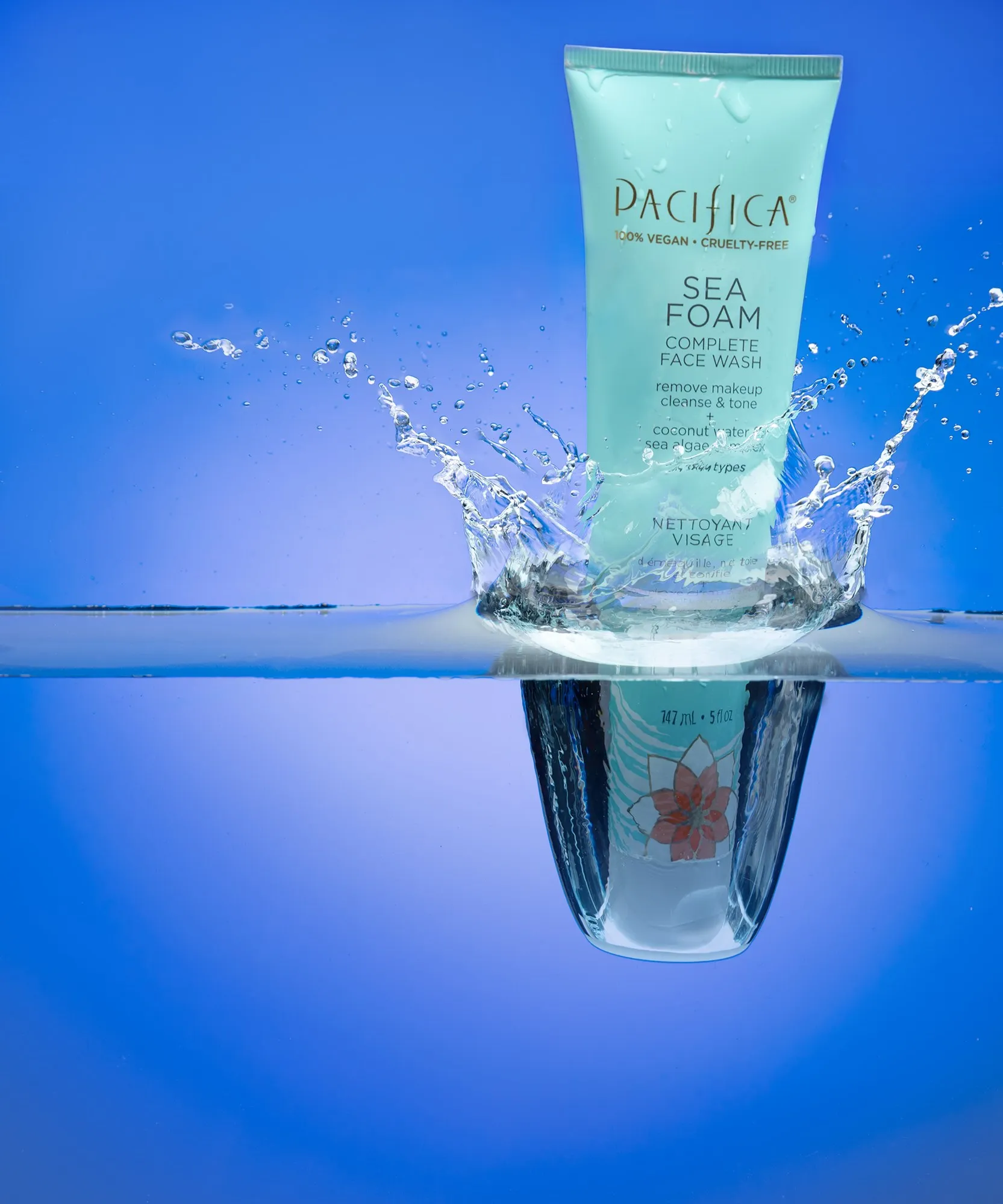 A cosmetic tube reflected in blue water with a splash