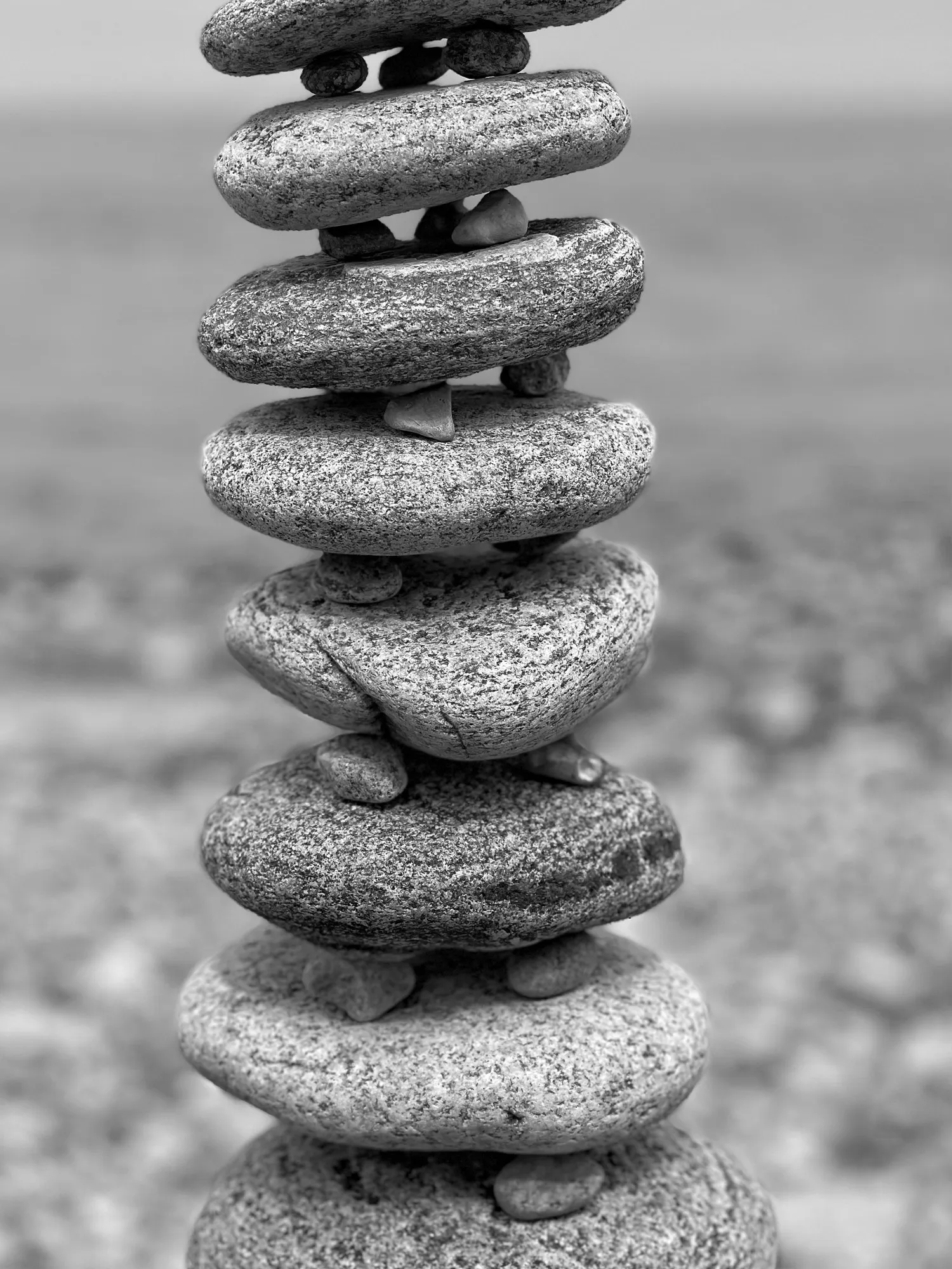 A black-and-white close view of a carefully balanced stone tower